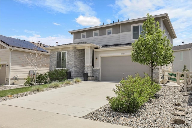 1886 Makley Loop, Castle Rock, CO 80104 - view of front of home featuring a garage, concrete driveway, stone siding, and fence