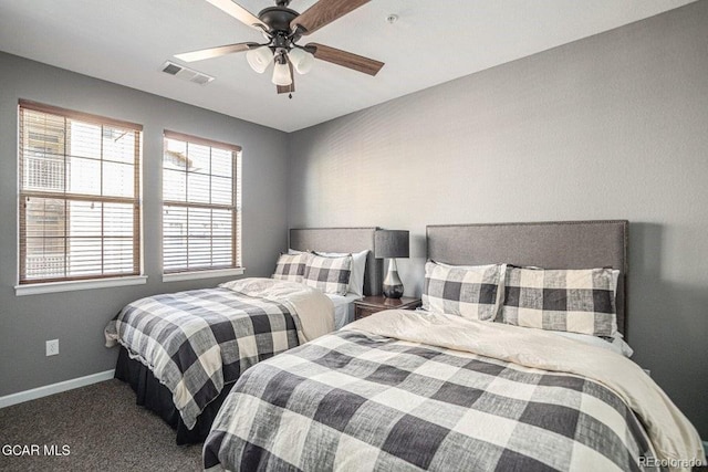 carpeted bedroom with visible vents, baseboards, and a ceiling fan