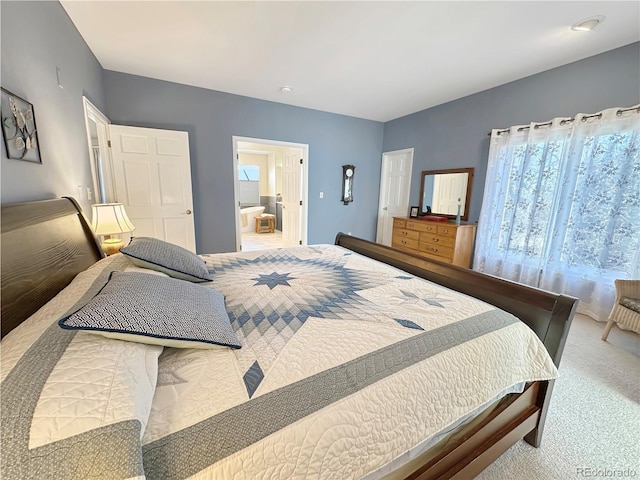 carpeted bedroom with ensuite bath and vaulted ceiling