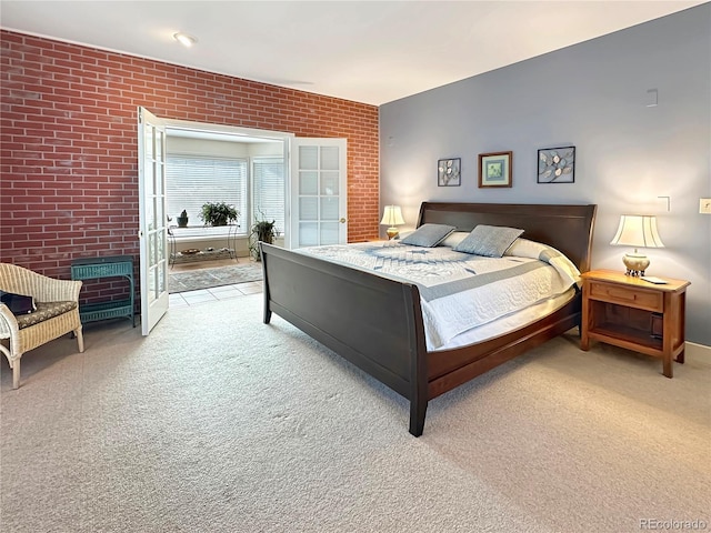 bedroom with light carpet and brick wall