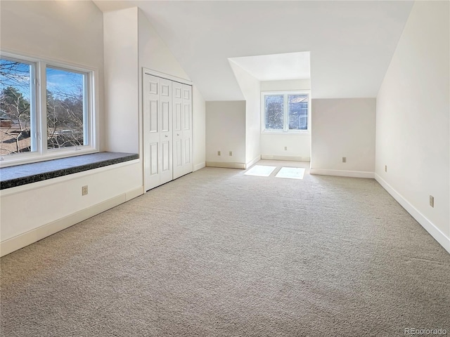 bonus room with baseboards, lofted ceiling, and carpet