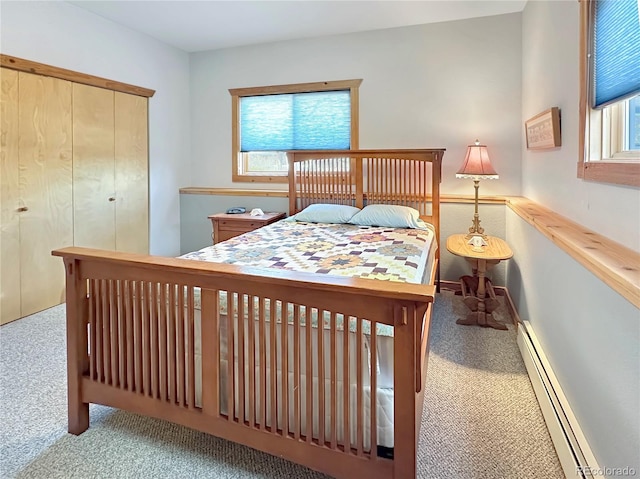 bedroom with a baseboard heating unit, multiple windows, and a closet