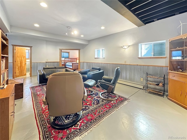 living room with recessed lighting, wainscoting, baseboard heating, and concrete flooring