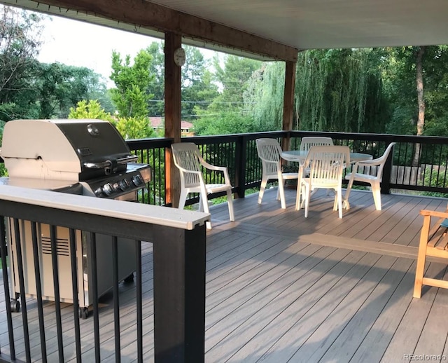 deck with a grill and outdoor dining space