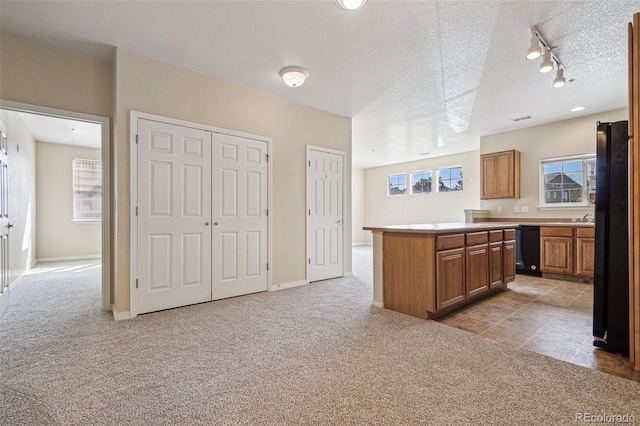 kitchen with light carpet, a center island, light countertops, and freestanding refrigerator