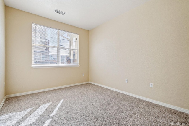 carpeted empty room with visible vents and baseboards