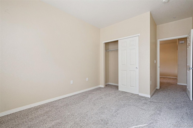 unfurnished bedroom with a closet, carpet flooring, and baseboards