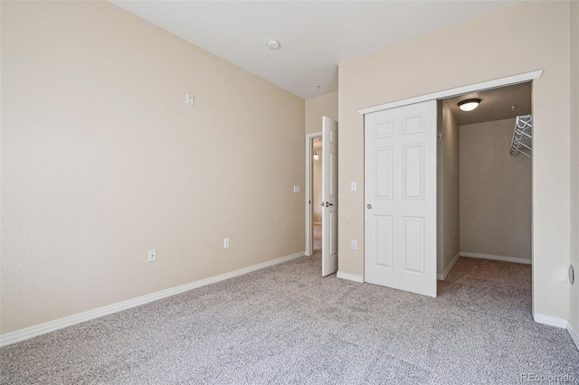 unfurnished bedroom featuring baseboards, a closet, and light colored carpet