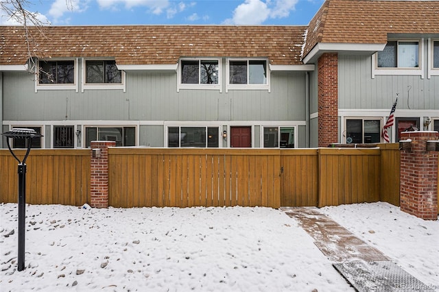 snow covered property with a fenced front yard