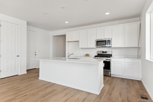 kitchen featuring white cabinets, an island with sink, and appliances with stainless steel finishes