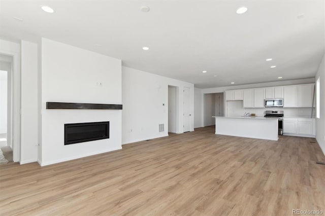 unfurnished living room featuring light wood-type flooring