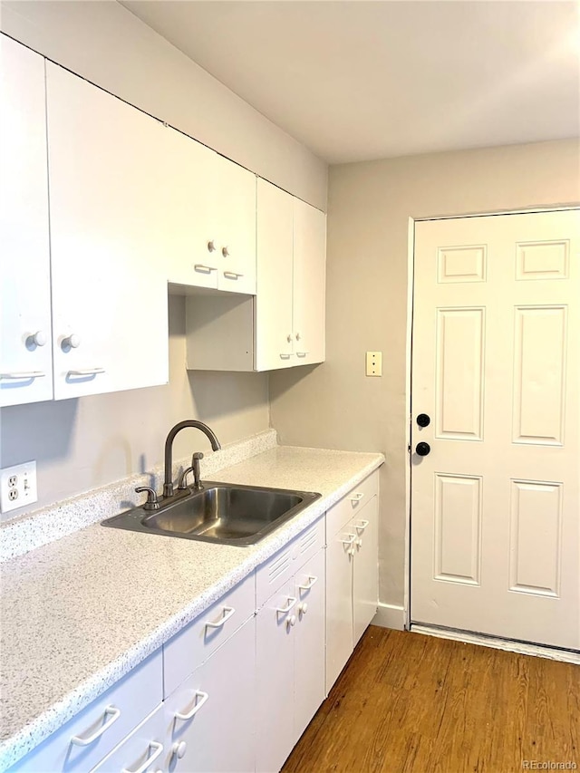 1143 Akron St, Aurora, CO 80010 - kitchen featuring a sink, dark wood finished floors, white cabinetry, and baseboards