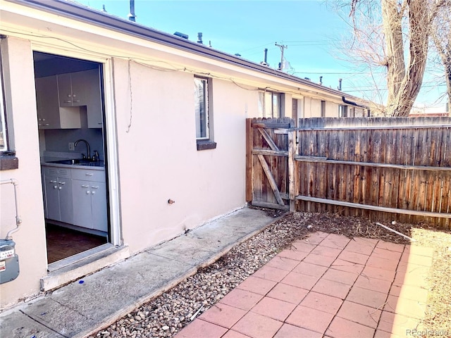 1143 Akron St, Aurora, CO 80010 - view of patio / terrace featuring a sink, a gate, and fence