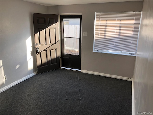 1143 Akron St, Aurora, CO 80010 - foyer entrance featuring dark colored carpet and baseboards