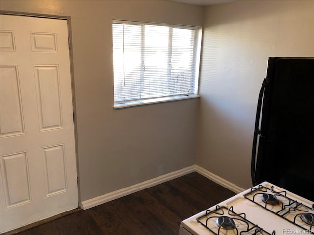 1143 Akron St, Aurora, CO 80010 - kitchen featuring white gas range oven, dark wood-style flooring, baseboards, and freestanding refrigerator