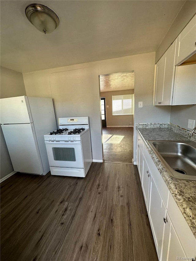 1143 Akron St, Aurora, CO 80010 - kitchen with white appliances, a sink, dark wood-style flooring, white cabinetry, and baseboards