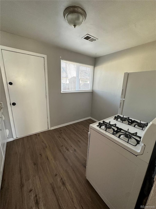 1143 Akron St, Aurora, CO 80010 - kitchen featuring white appliances, dark wood-type flooring, and baseboards