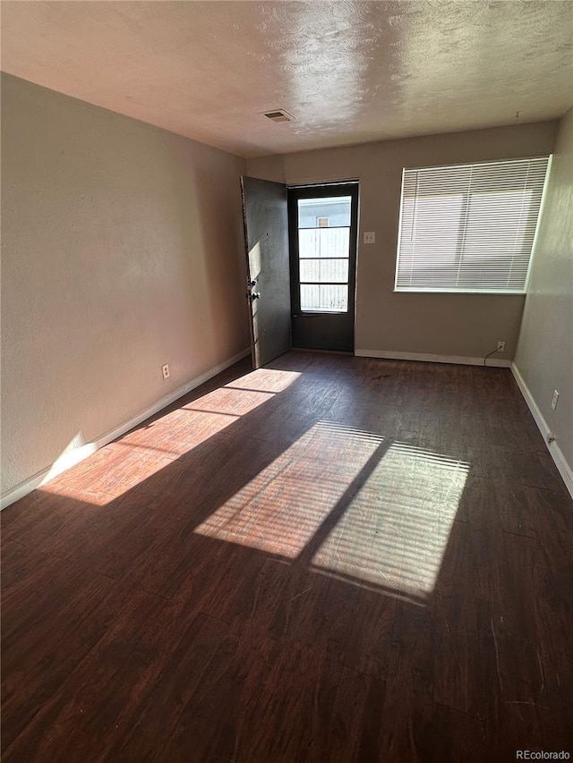 1143 Akron St, Aurora, CO 80010 - spare room featuring wood finished floors, baseboards, and a textured ceiling