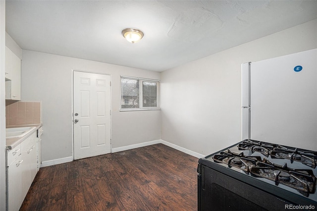 1143 Akron St, Aurora, CO 80010 - kitchen featuring freestanding refrigerator, black range with gas cooktop, dark wood-style floors, white cabinets, and light countertops