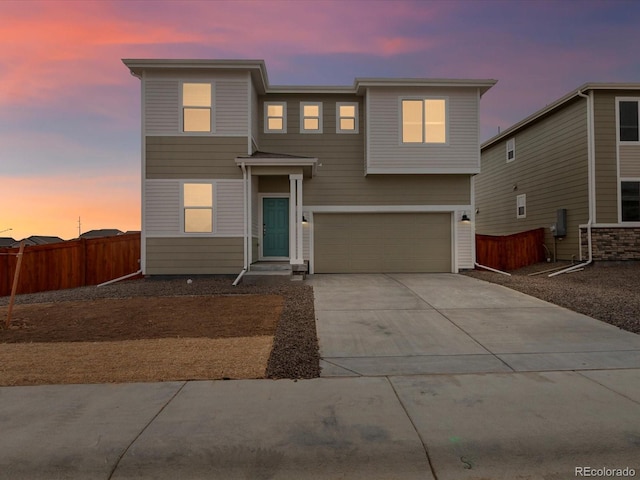 view of front of property with concrete driveway, fence, and a garage