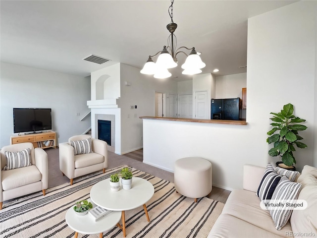 12713 Leyden St Unit E, Thornton, CO 80602 - living room featuring a chandelier, a glass covered fireplace, baseboards, and recessed lighting