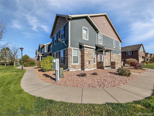 12713 Leyden St Unit E, Thornton, CO 80602 - view of front of house featuring stone siding and a front yard