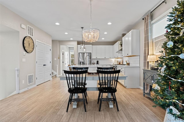 dining room featuring light hardwood / wood-style floors and a notable chandelier