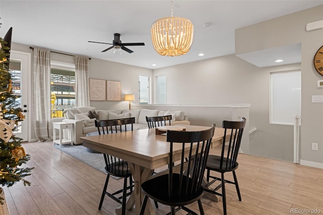 dining room featuring ceiling fan with notable chandelier and light wood-type flooring