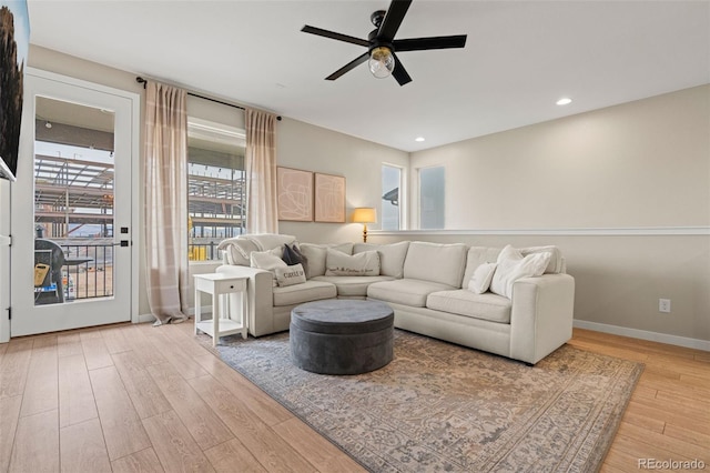 living room featuring light hardwood / wood-style flooring and ceiling fan