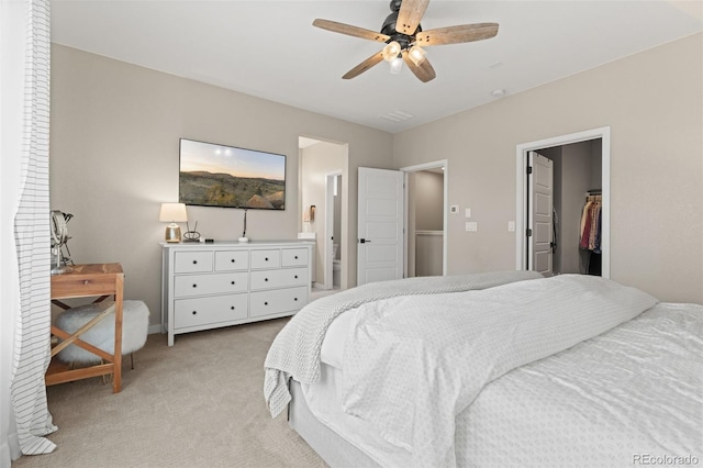 carpeted bedroom featuring connected bathroom, ceiling fan, a closet, and a spacious closet