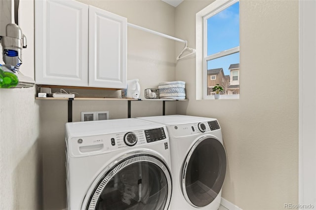 laundry room with washer and dryer and cabinets