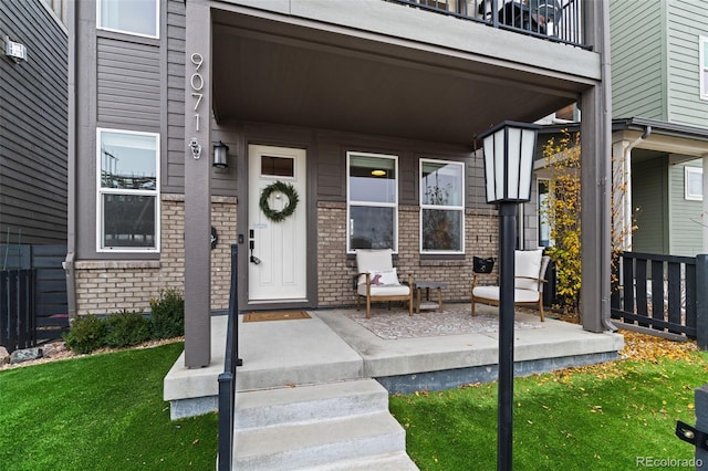 property entrance featuring a balcony and a porch