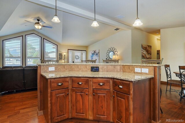 kitchen featuring a kitchen bar, vaulted ceiling with beams, pendant lighting, and a center island