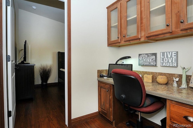 office featuring built in desk and dark hardwood / wood-style flooring