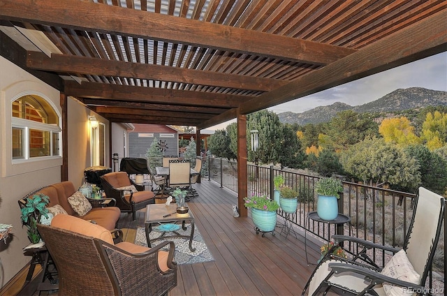 deck with a pergola, a mountain view, and an outdoor living space