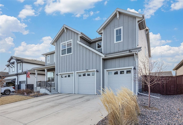 view of front of property featuring concrete driveway, board and batten siding, an attached garage, and fence