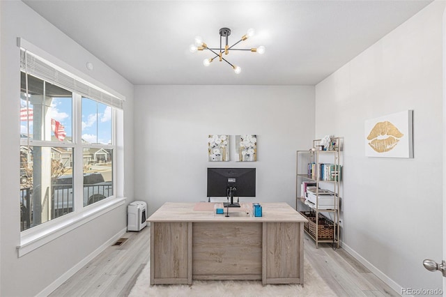 office space with light wood-type flooring, a notable chandelier, and baseboards