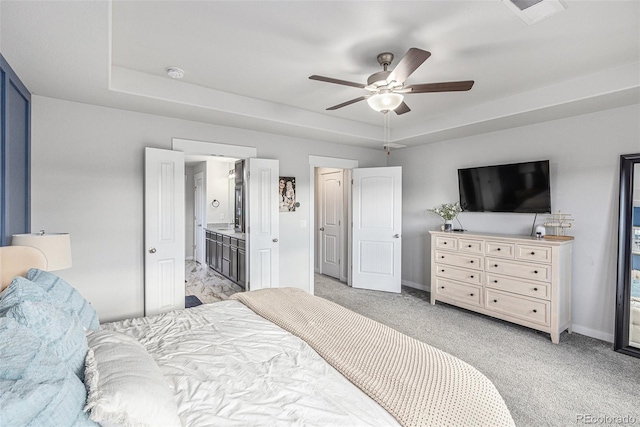 bedroom with baseboards, visible vents, a tray ceiling, and light colored carpet