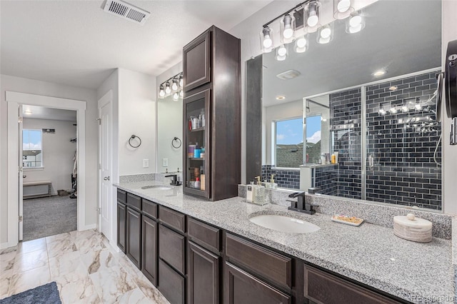 bathroom with a healthy amount of sunlight, marble finish floor, visible vents, and a sink