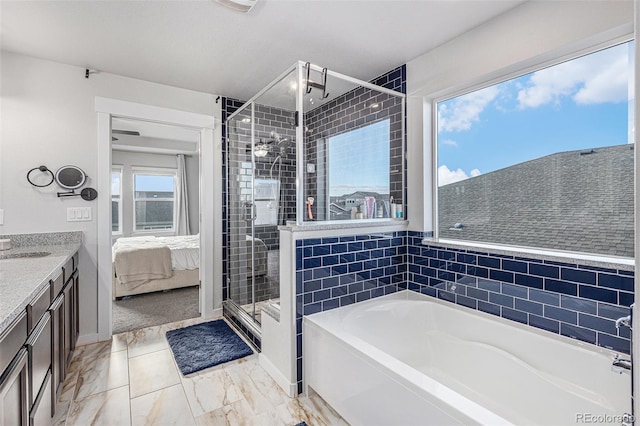 ensuite bathroom with a garden tub, connected bathroom, vanity, marble finish floor, and a stall shower