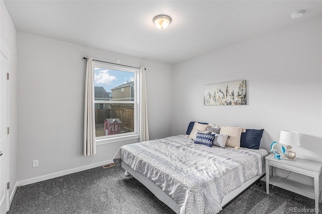 bedroom with visible vents, baseboards, and dark colored carpet