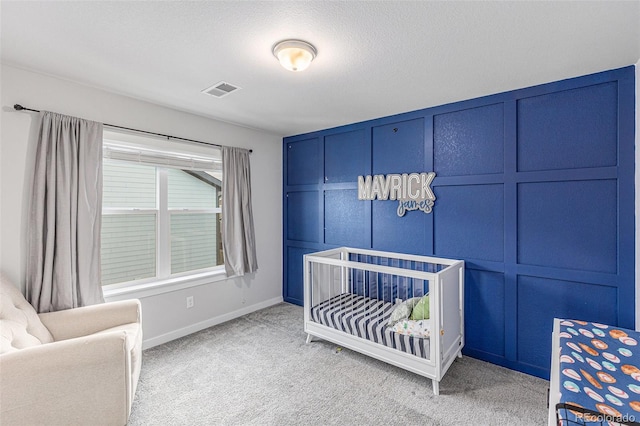 carpeted bedroom with baseboards, visible vents, and a decorative wall