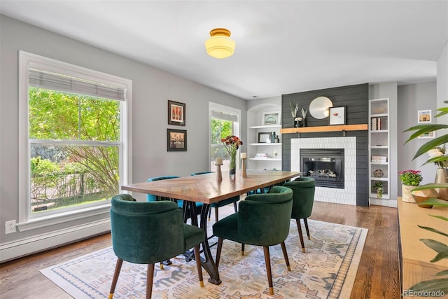 3330 E Tennessee Ave, Denver, CO 80209 - dining room featuring a large fireplace, built in features, and wood finished floors