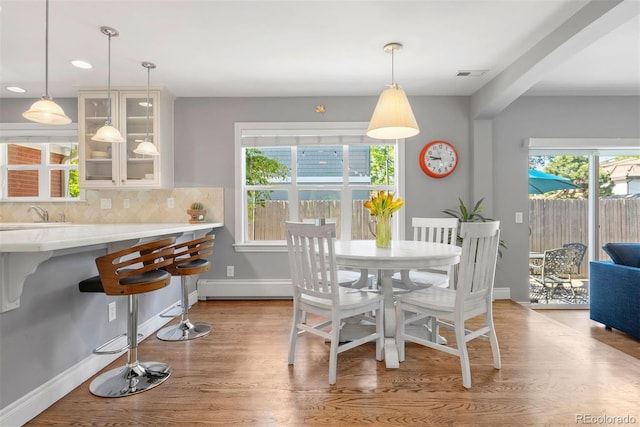 3330 E Tennessee Ave, Denver, CO 80209 - dining room featuring a baseboard heating unit, wood finished floors, baseboards, and recessed lighting