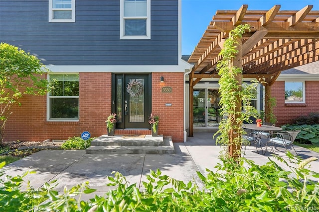 3330 E Tennessee Ave, Denver, CO 80209 - view of exterior entry featuring a pergola, brick siding, and a patio