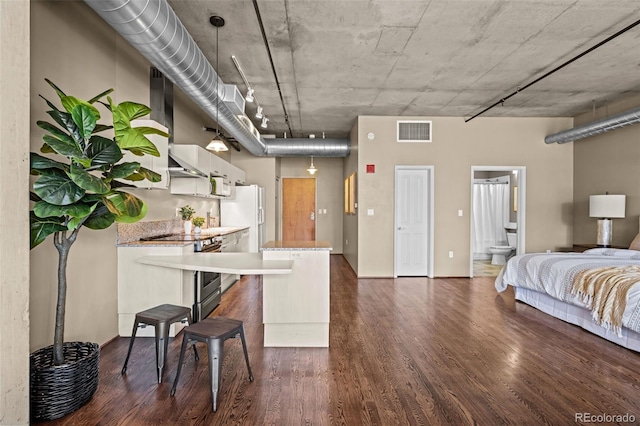 1499 Blake St Unit 2C, Denver, CO 80202 - kitchen with dark wood-style flooring, open floor plan, stainless steel range with electric cooktop, a breakfast bar, and white refrigerator with ice dispenser