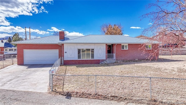 single story home with metal roof, an attached garage, fence private yard, and concrete driveway