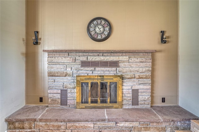 interior details featuring a stone fireplace and visible vents