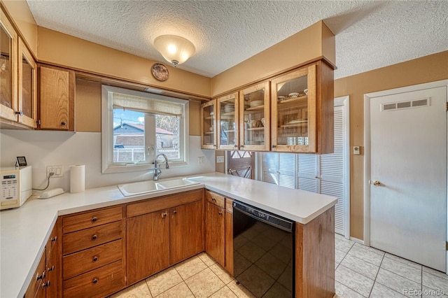 kitchen with visible vents, light countertops, black dishwasher, a peninsula, and a sink