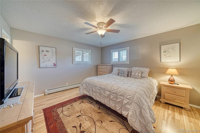 bedroom featuring ceiling fan, a baseboard radiator, baseboards, and wood finished floors